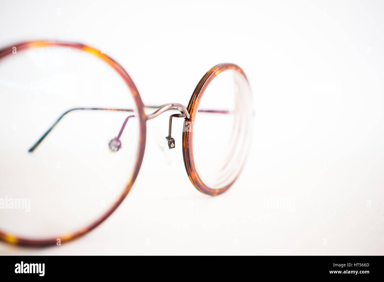 Occhiali Vintage sulla tela bianca su sfondo di carta vicino. Foto Stock