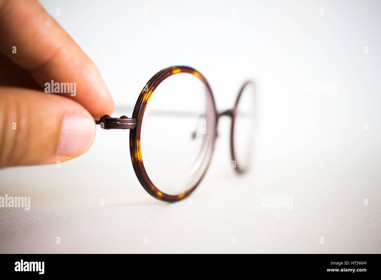 Occhiali Vintage sulla tela bianca su sfondo di carta vicino. Foto Stock