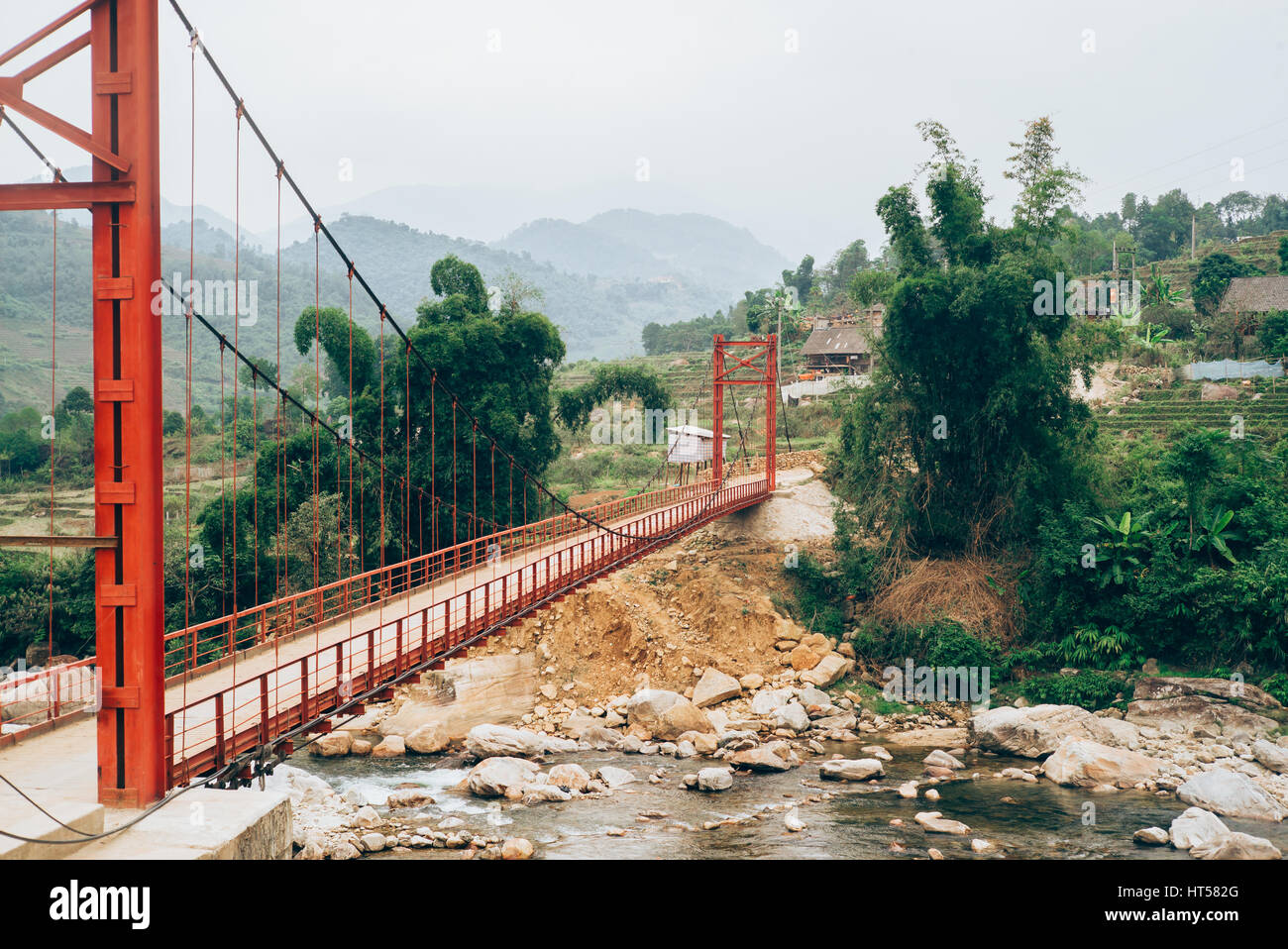 Ponte rosso di attraversare un fiume di montagna di Sapa, il nord del Vietnam Foto Stock
