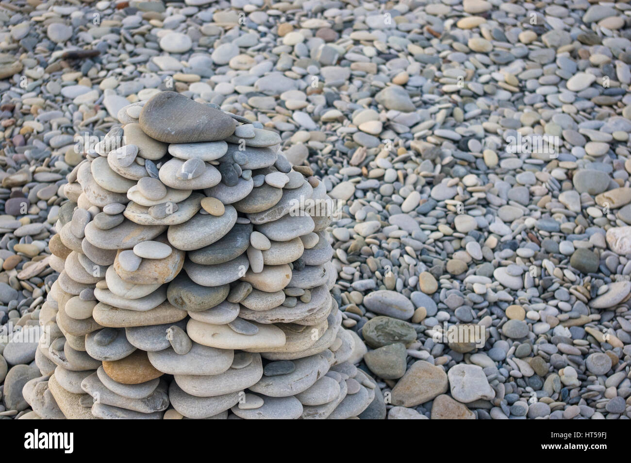Piramide piegata Zen pietre ghiaia sul mare spiaggia al tramonto Foto Stock