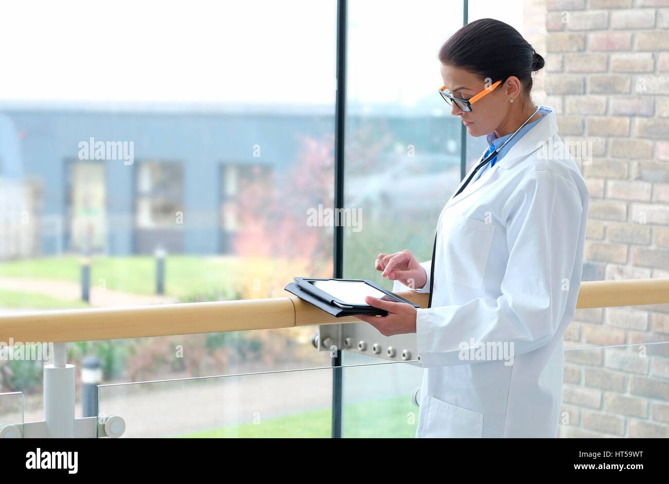 Medico donna nel centro medico utilizzando computer tablet ipad Foto Stock
