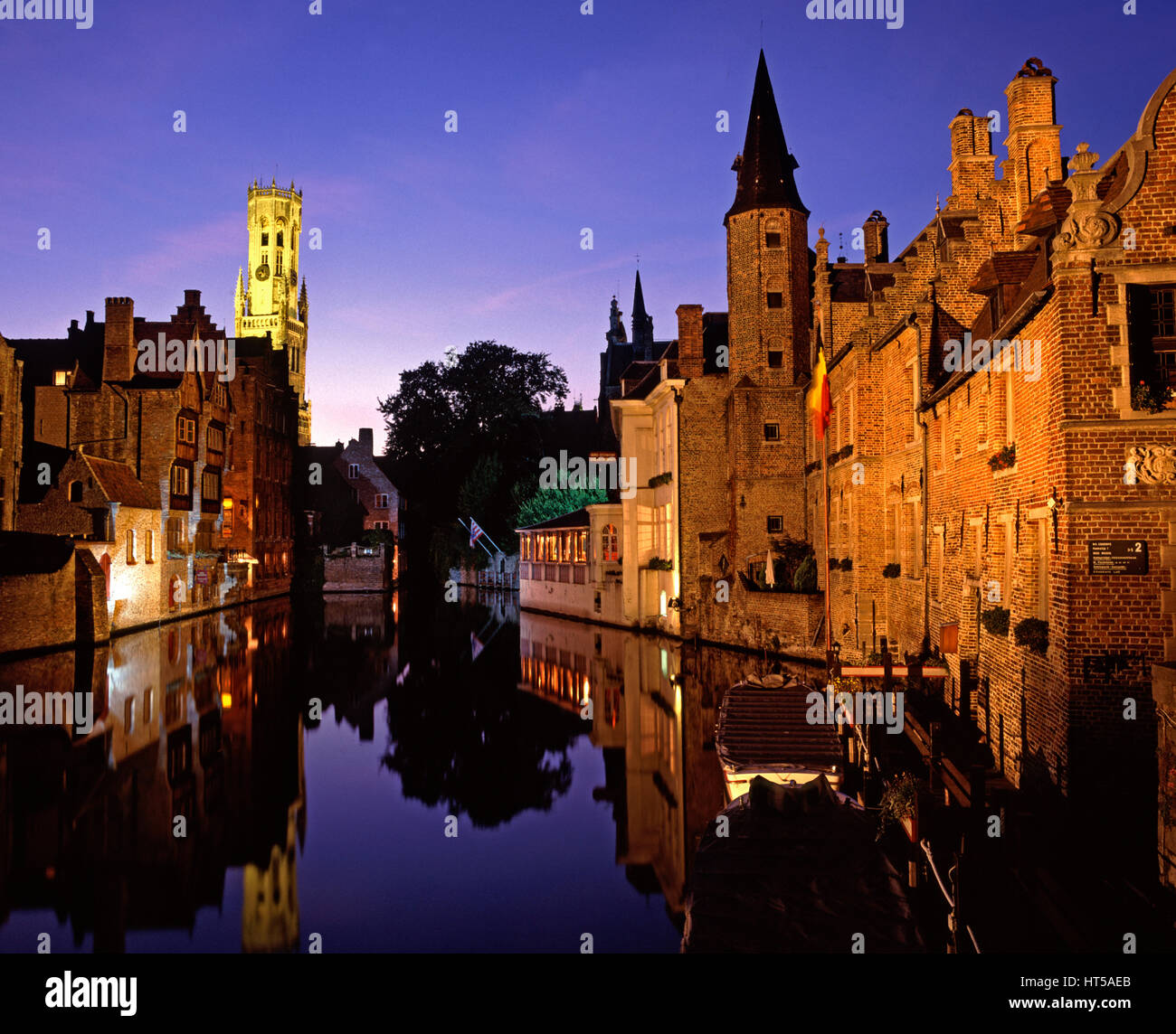 Il Dijver Canal e campanile illuminato al crepuscolo, Bruges, Belgio. Foto Stock