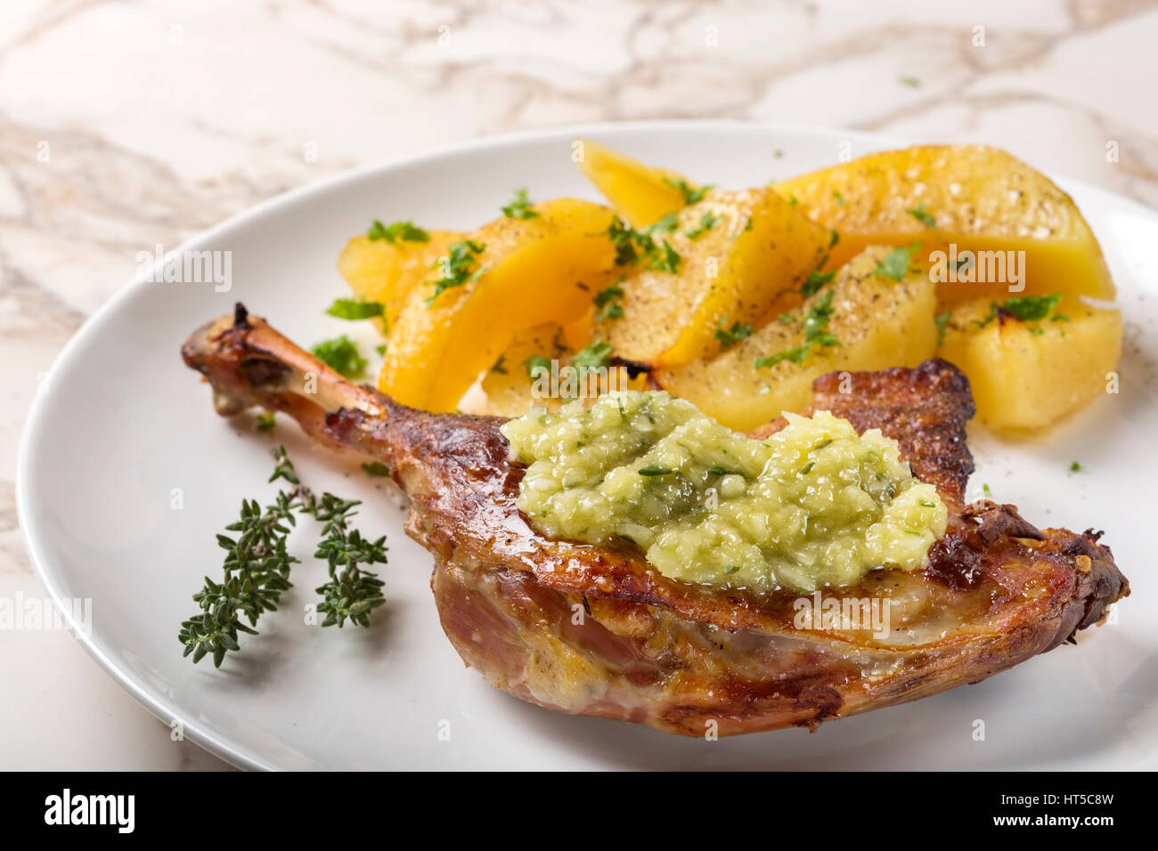 Anatra arrosto con patate dorate e salsa di aglio con le erbe su piastra Foto Stock