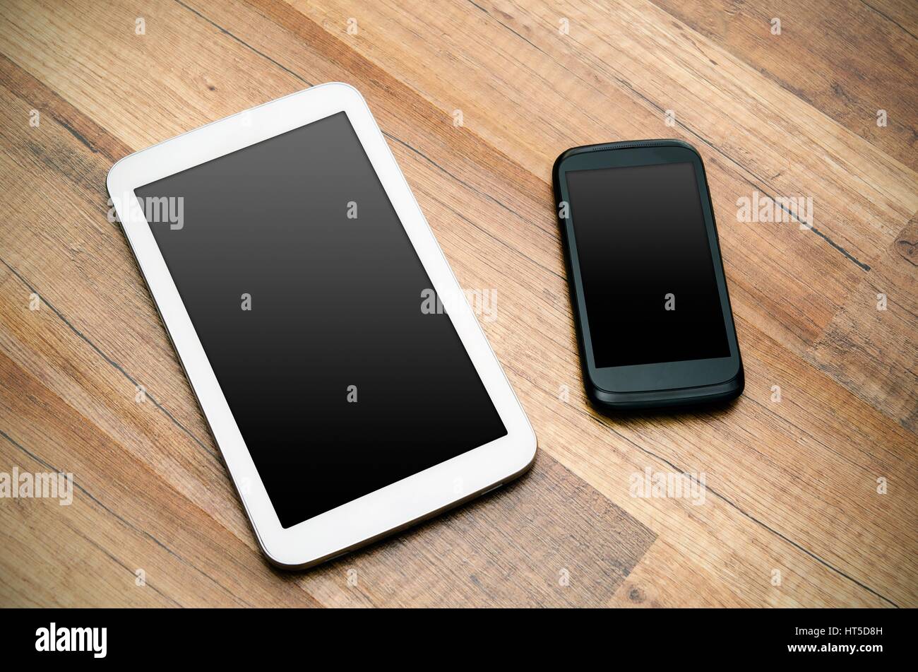Telefono cellulare e tablet con display vuoto od sfondo di legno Foto Stock