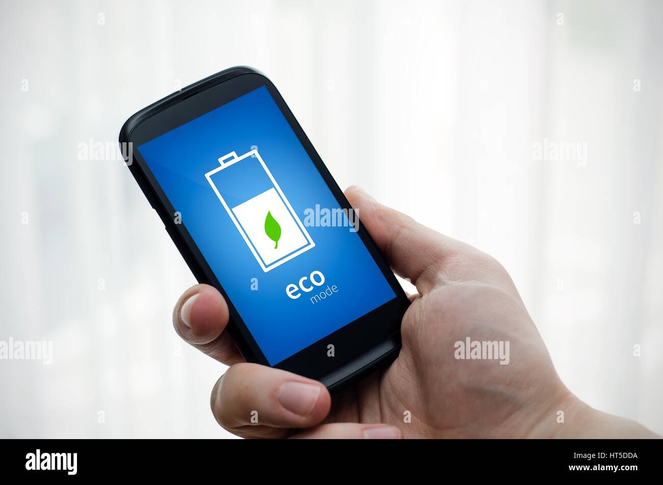 Uomo con telefono economico con modalità batteria sul display Foto Stock