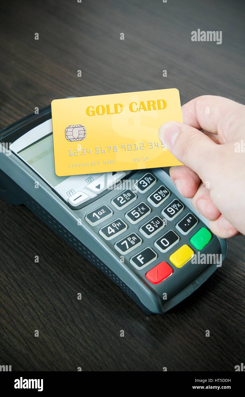 Uomo paga una carta oro in terminale di pagamento Foto Stock