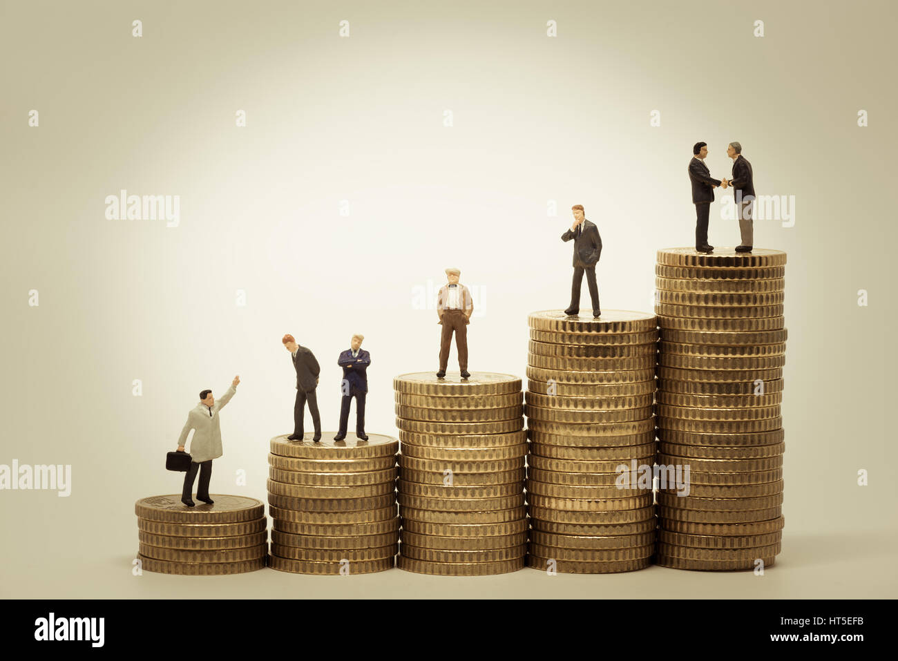 Varie persone in piedi su pile di monete. Foto Stock