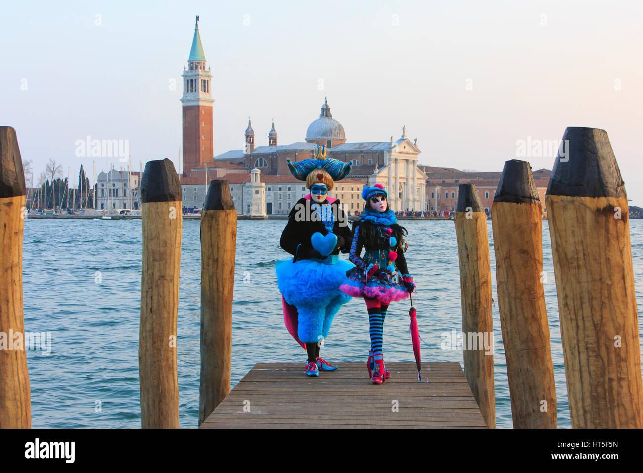 Due persone in costumi su una barca sbarco al di fuori di San Giorgio Maggiore durante il Carnevale di Venezia, Italia Foto Stock