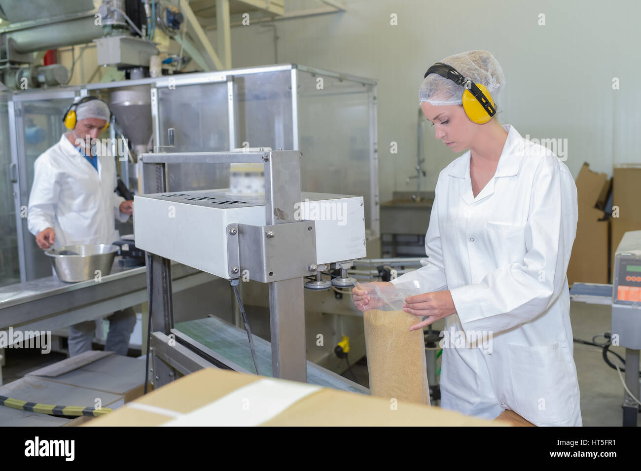 Due persone che lavorano in fabbrica la linea di produzione Foto Stock