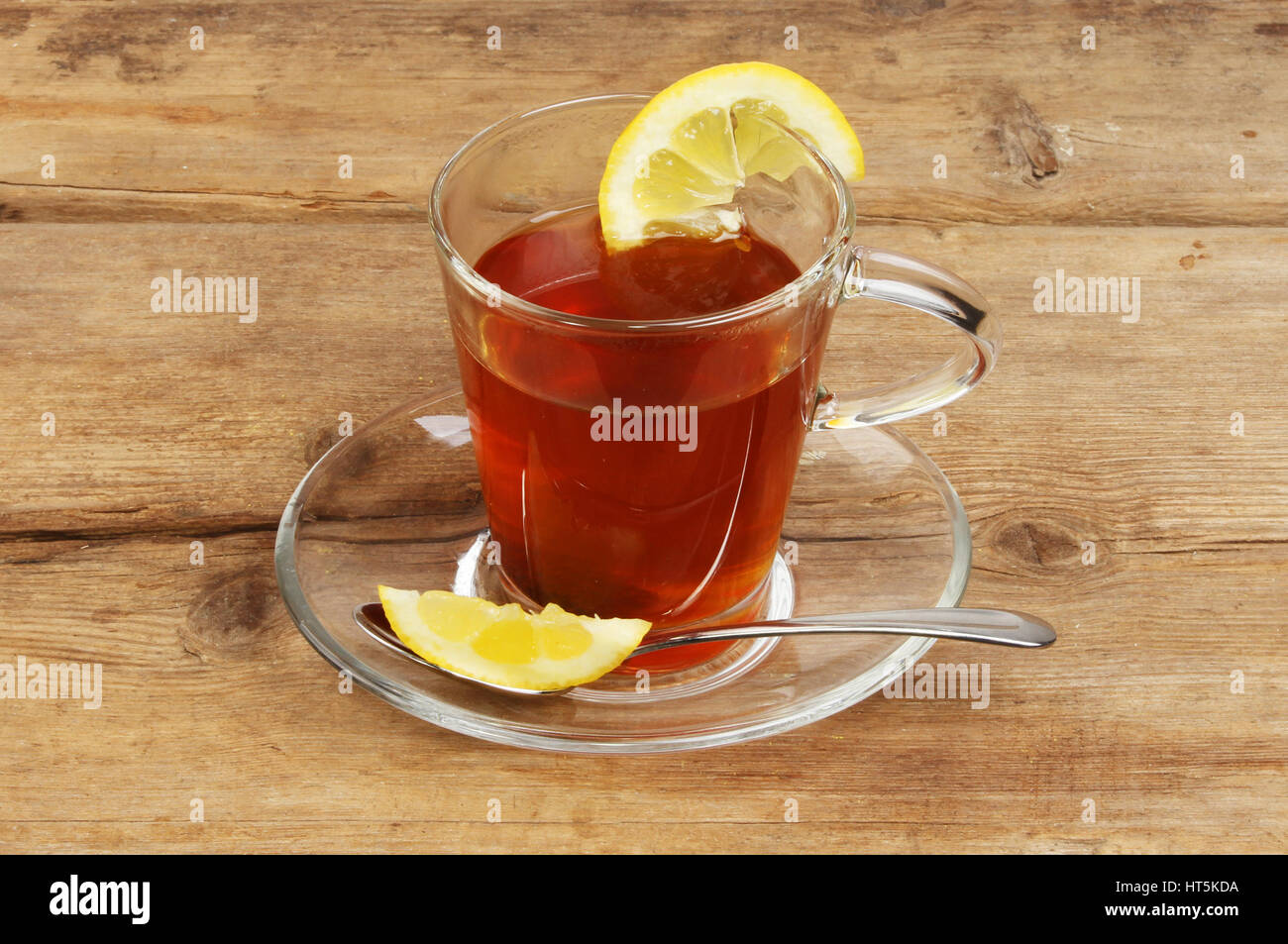Tè al limone in un vetro trasparente e coppa piattino sul vecchio legno ustic Foto Stock