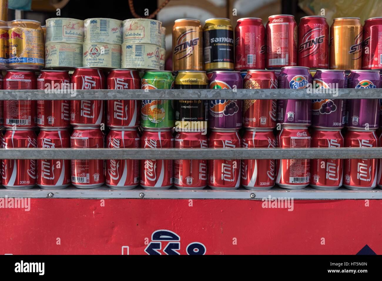 Le lattine di frizzanti bevande analcoliche impilati in righe. Kampot, Cambogia Foto Stock