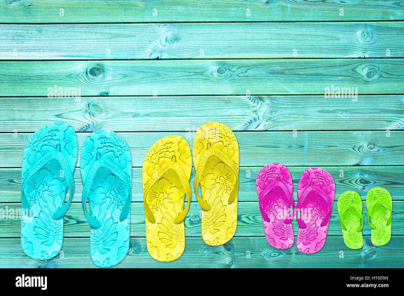 Colorato flip-flop di una famiglia su tavole di legno sfondo Foto stock -  Alamy