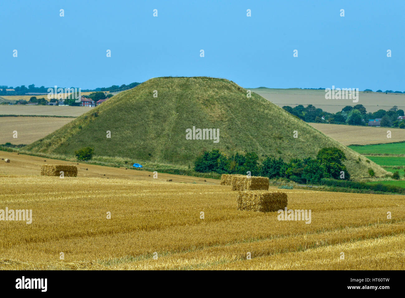 Raccolta estiva con balle di fieno accanto a Silbury Hill, Wiltshire UK Foto Stock