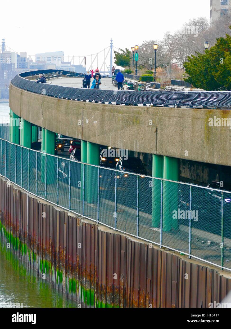 Pedoni godetevi la passeggiata di Carl Schurz Park mentre i pendolari drive sul FDR Parkway al di sotto. New York, New York, Stati Uniti d'America. Foto Stock