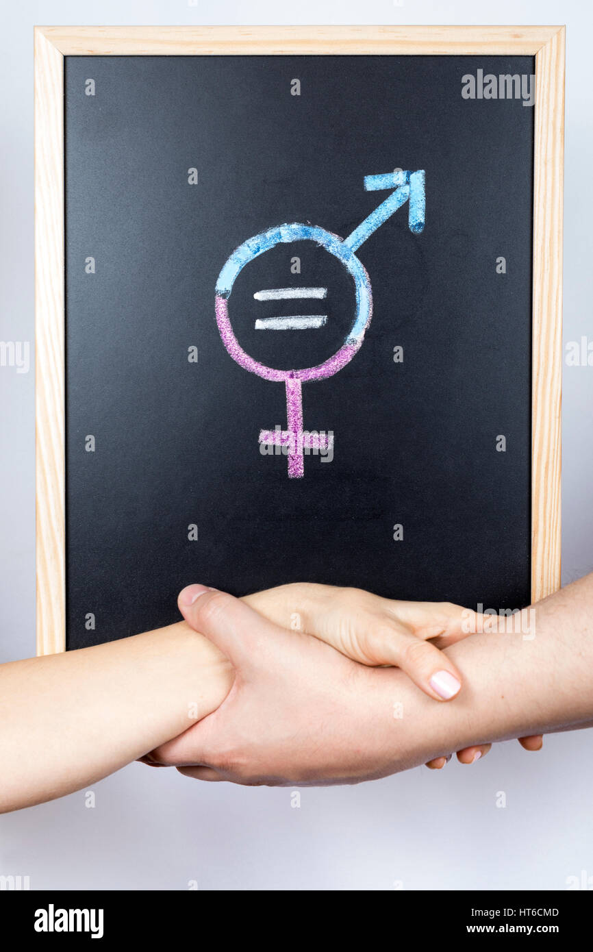 Le mani di un uomo e di una donna che tiene insieme una lavagna con il  simbolo di parità tra i sessi Foto stock - Alamy