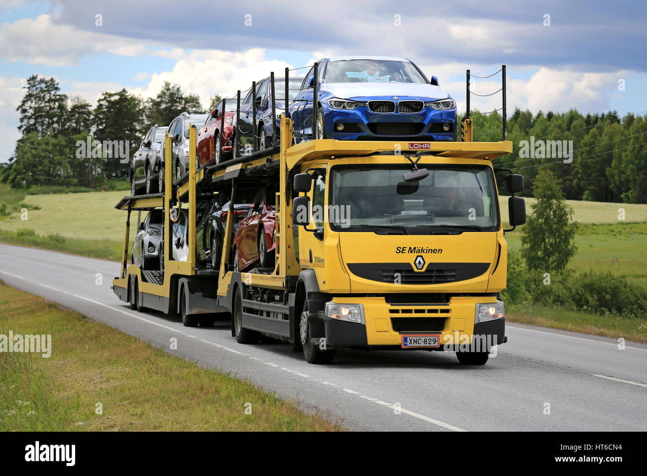 KARJAA, Finlandia - 11 giugno 2016: Giallo Renault Premium car carrier di sè Makinen trasporta nuove vetture lungo l'autostrada su una bella giornata d'estate. Foto Stock