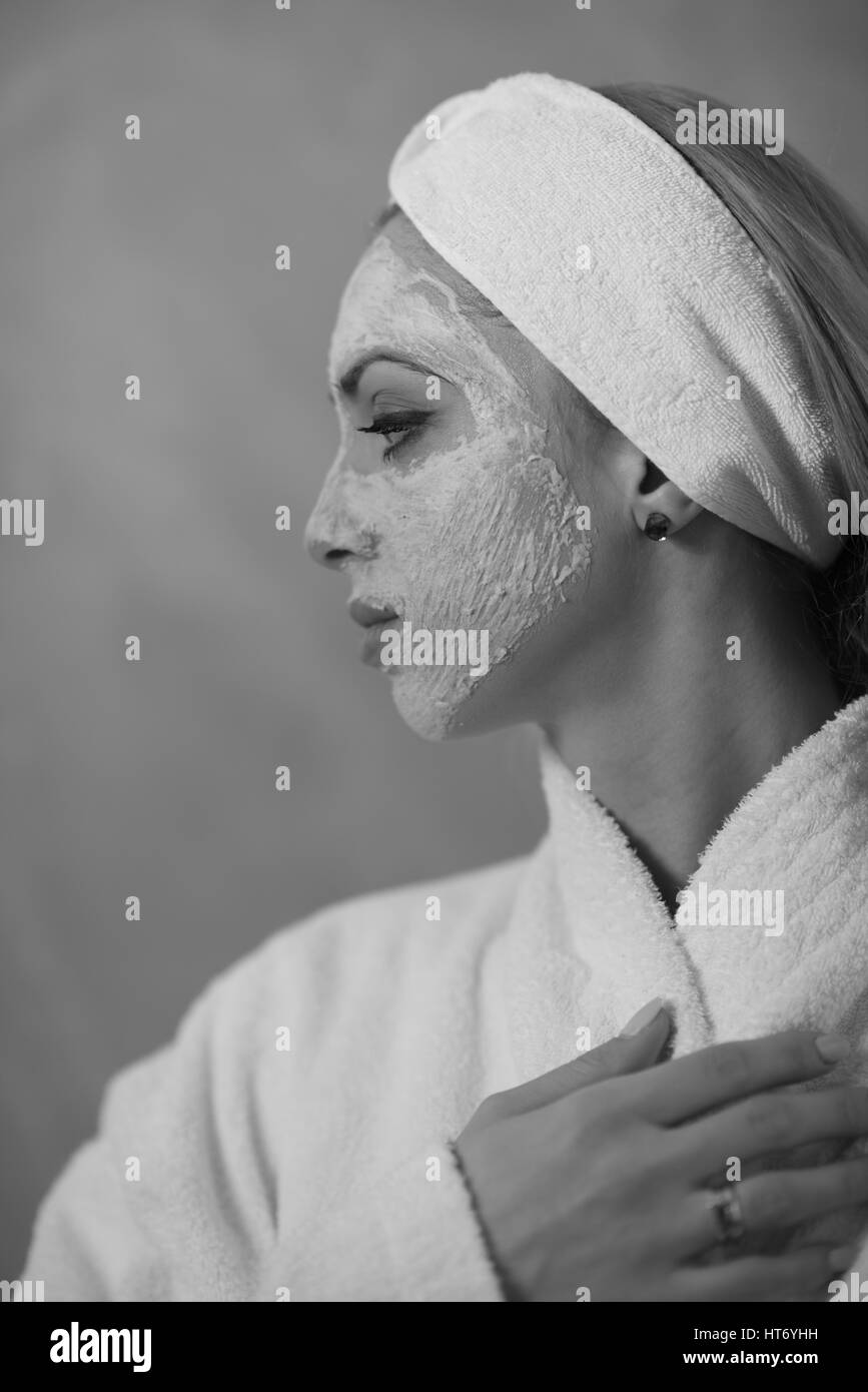 Spa donna applicando la maschera per il viso Trattamenti di bellezza Close up ritratto della bella ragazza con un asciugamano sul suo capo di applicare la maschera per il viso Foto Stock