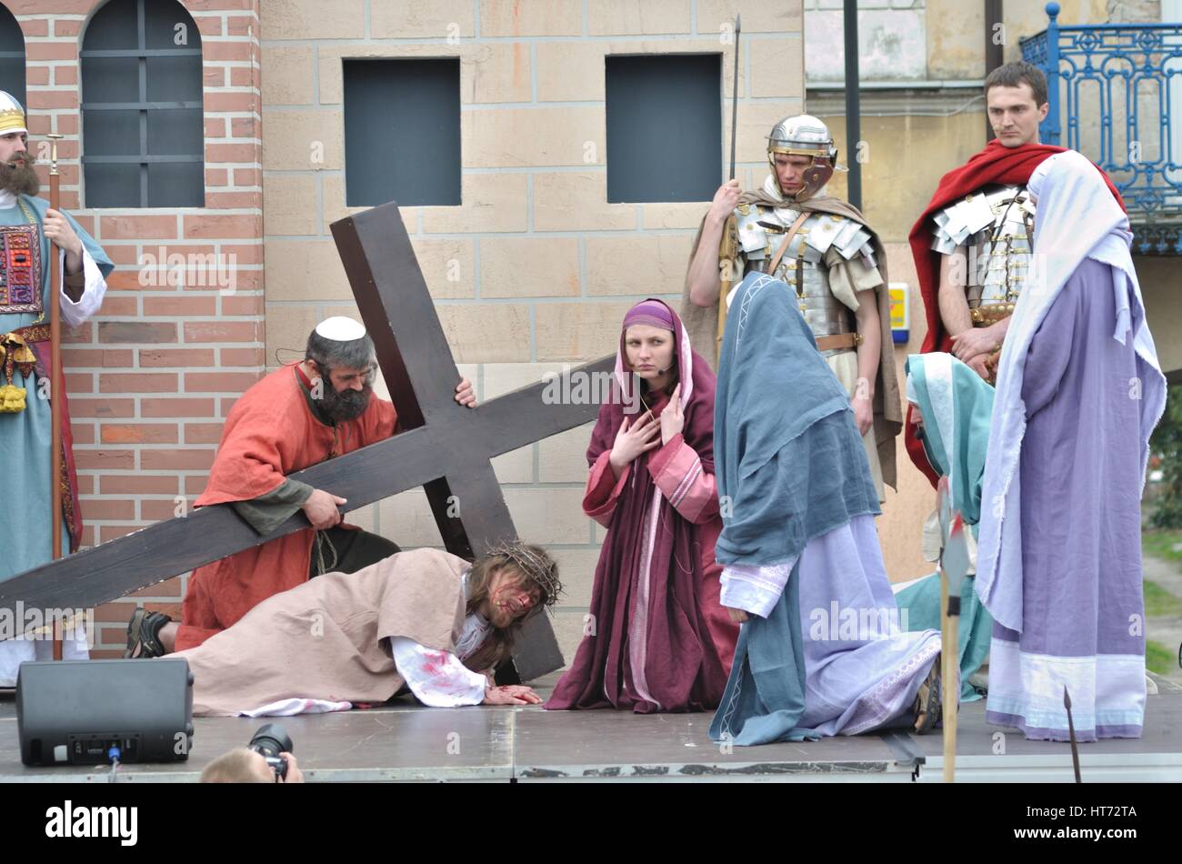 Gesù cade sulla strada per la sua crocifissione, durante gli spettacoli di strada mistero della passione. Foto Stock
