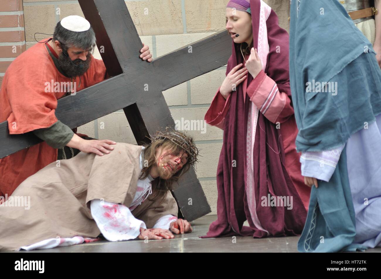 Gesù cade sulla strada per la sua crocifissione, durante gli spettacoli di strada mistero della passione. Foto Stock