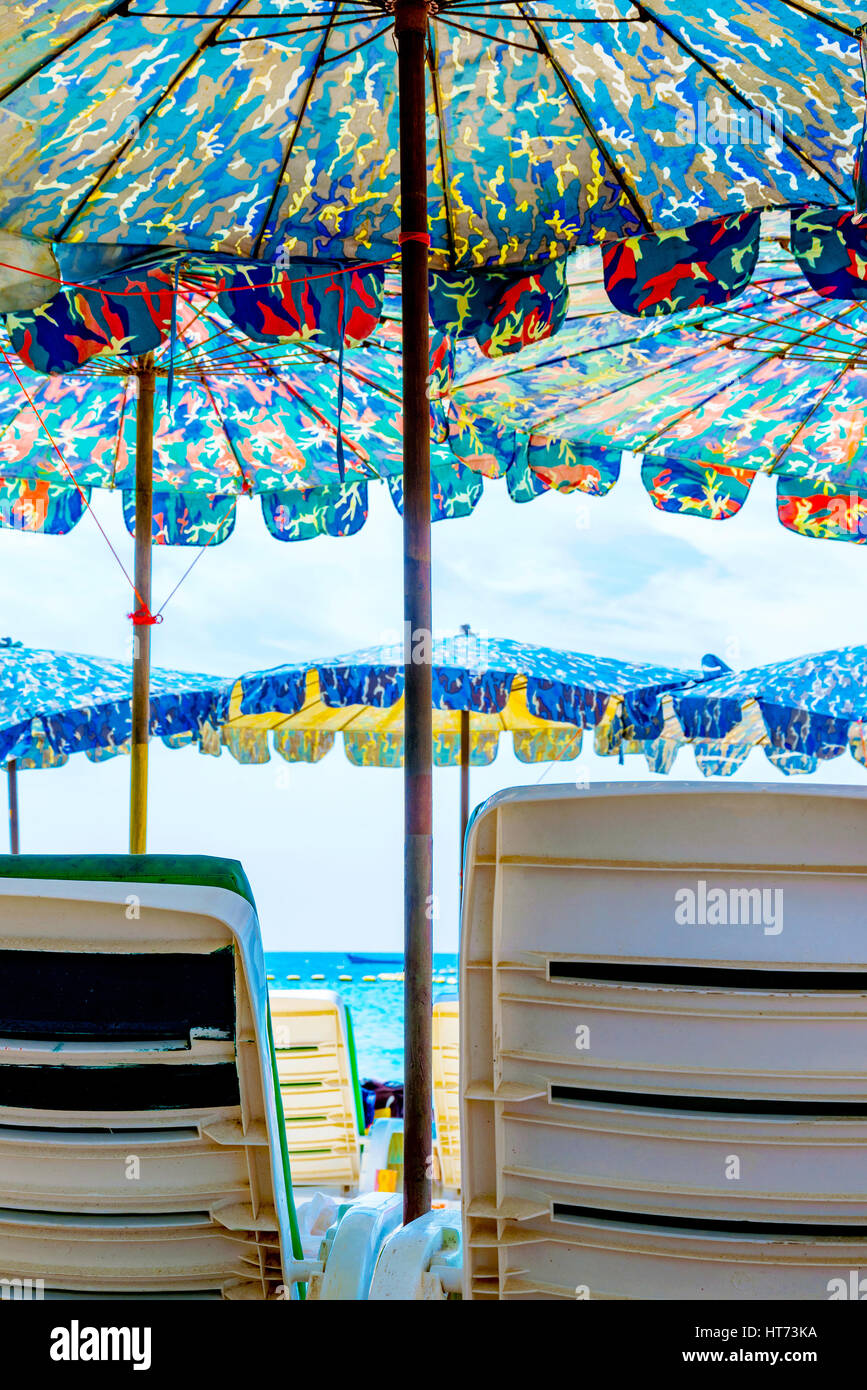 Lettini e ombrelloni da spiaggia in una giornata di sole in Thailandia Foto Stock