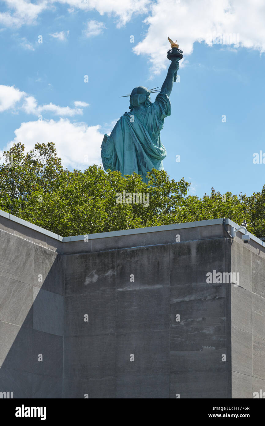 Statua della Libertà indietro visto dietro un muro in una giornata di sole Foto Stock