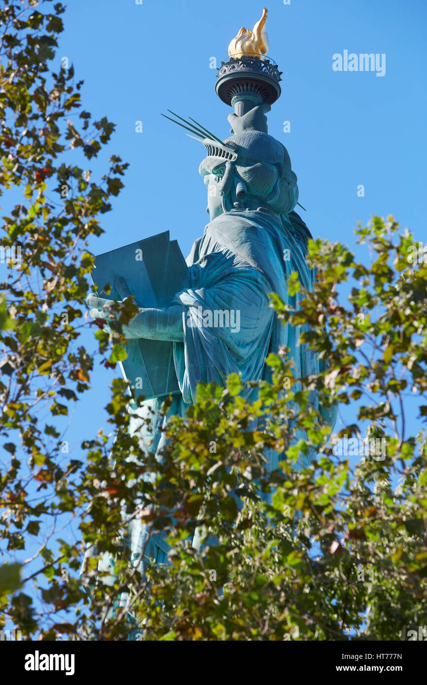 Statua della Libertà in una giornata di sole, attraverso gli alberi Foto Stock