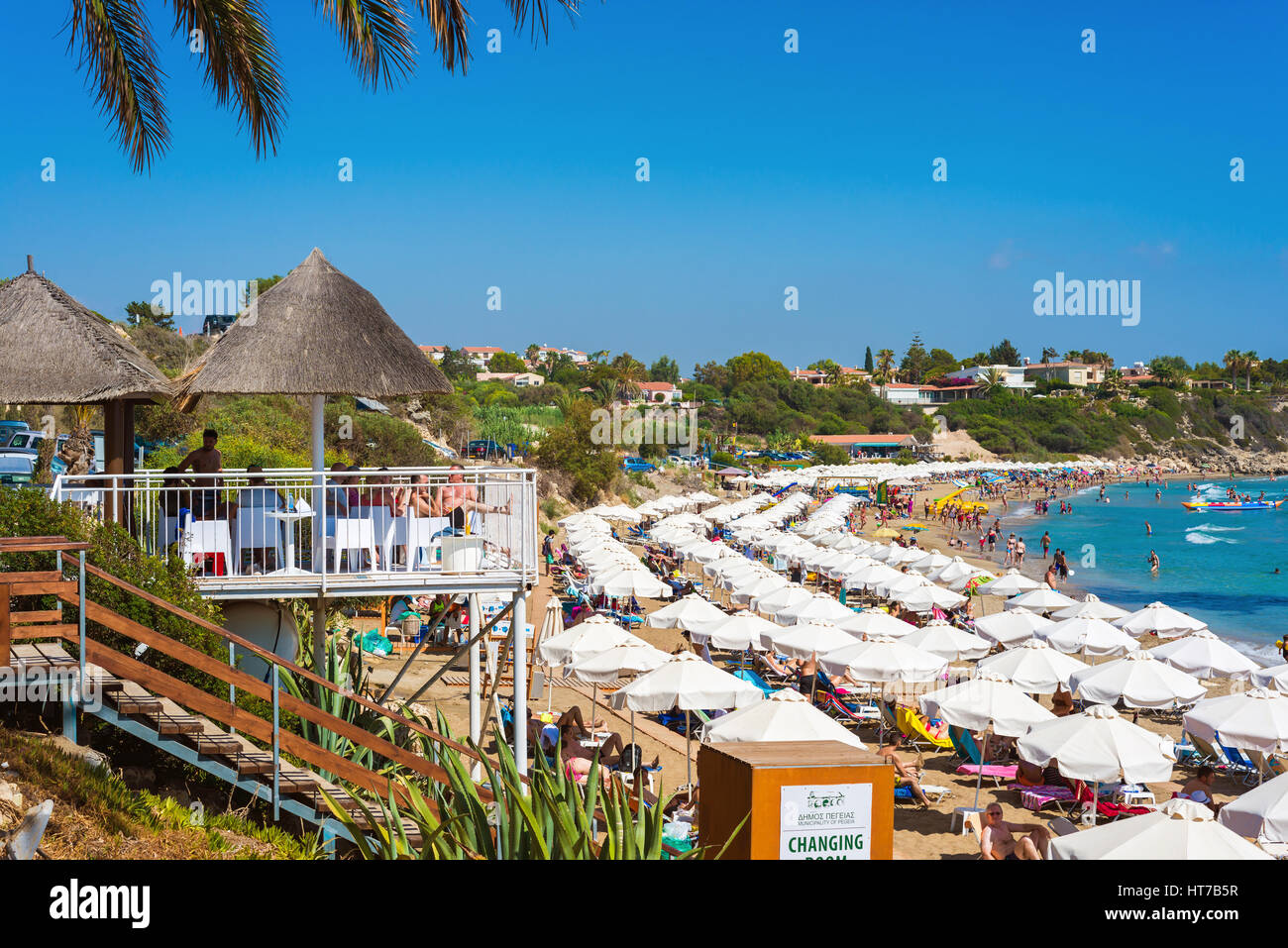 PAPHOS, Cipro - Luglio 24, 2016: turisti, lettini e ombrelloni a Coral Bay Beach. Foto Stock