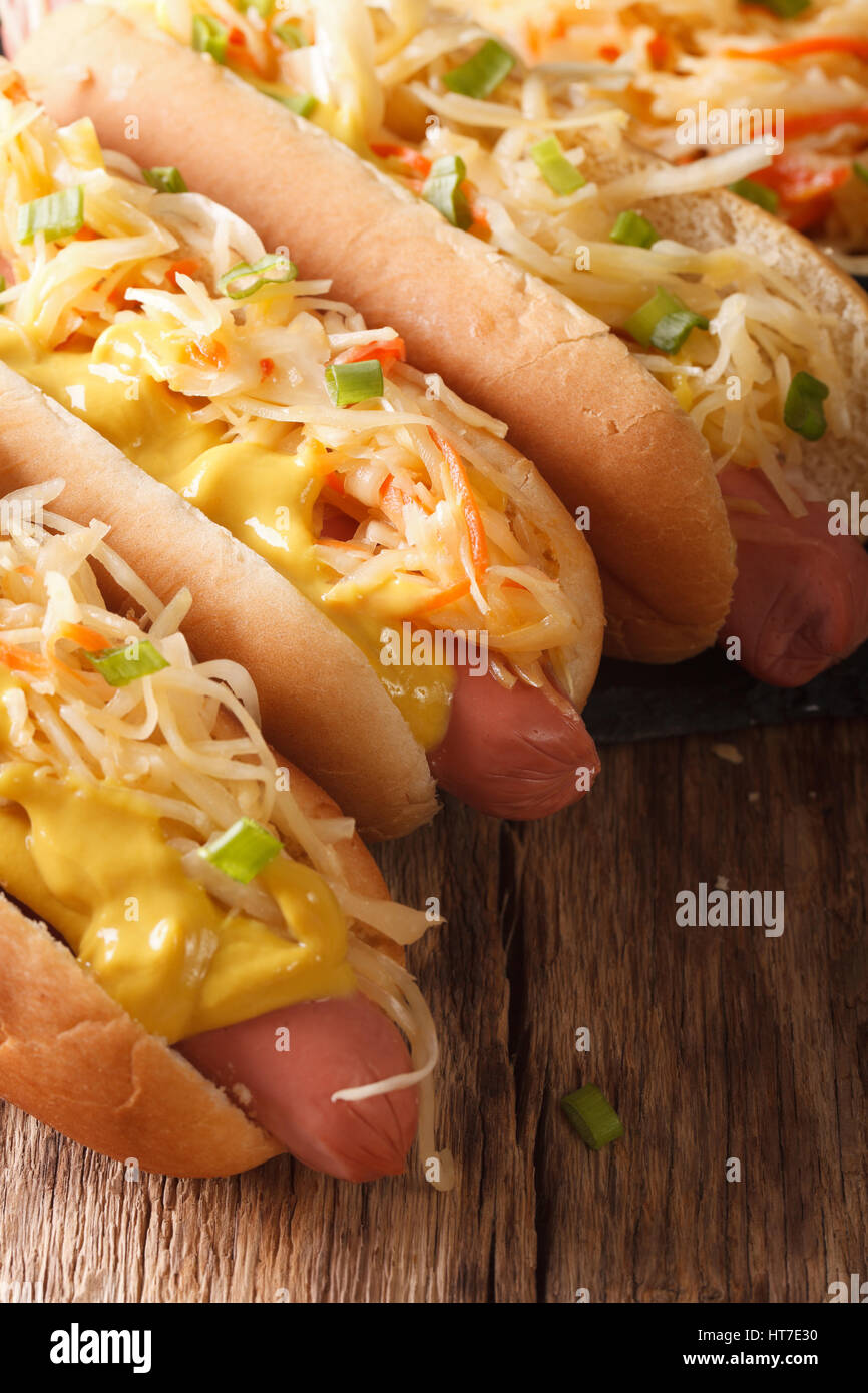 Panino con salsiccia, crauti e senape close up sul piano verticale. Foto Stock