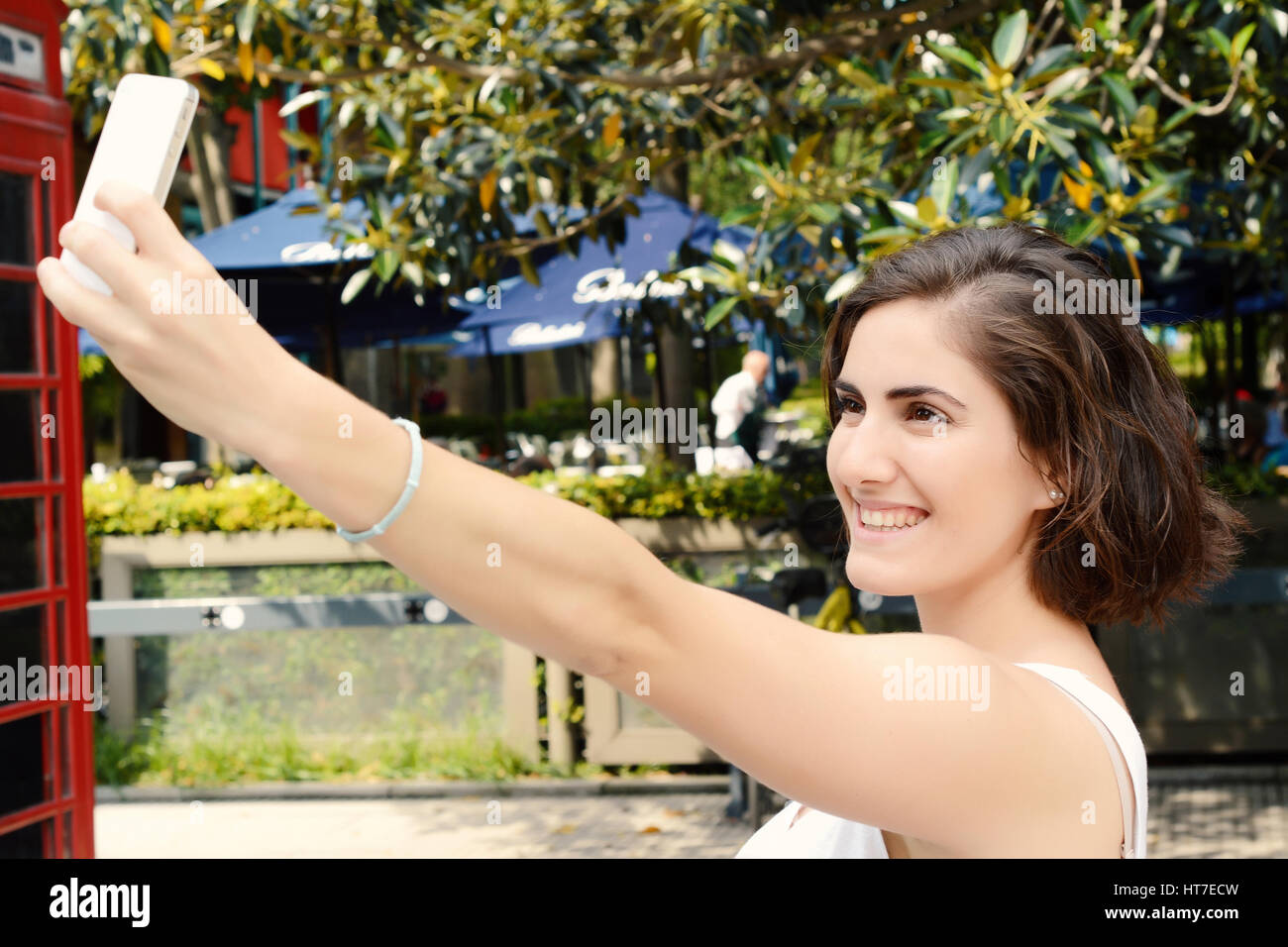 Ritratto di una giovane donna bellissima tenendo selfie con il suo smartphone. All'esterno. Foto Stock