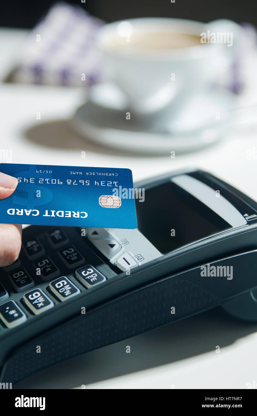 Donna mano utilizzando il terminale di pagamento nel ristorante Foto Stock