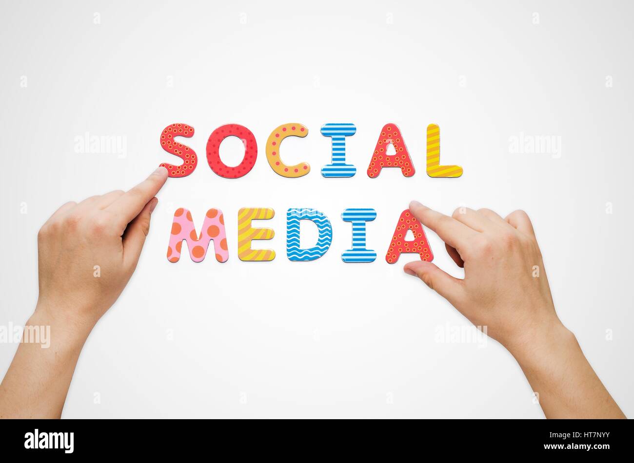 Mani mettere le parole dei Social Media con le lettere magnetiche. Alfabeto colorato kit Foto Stock