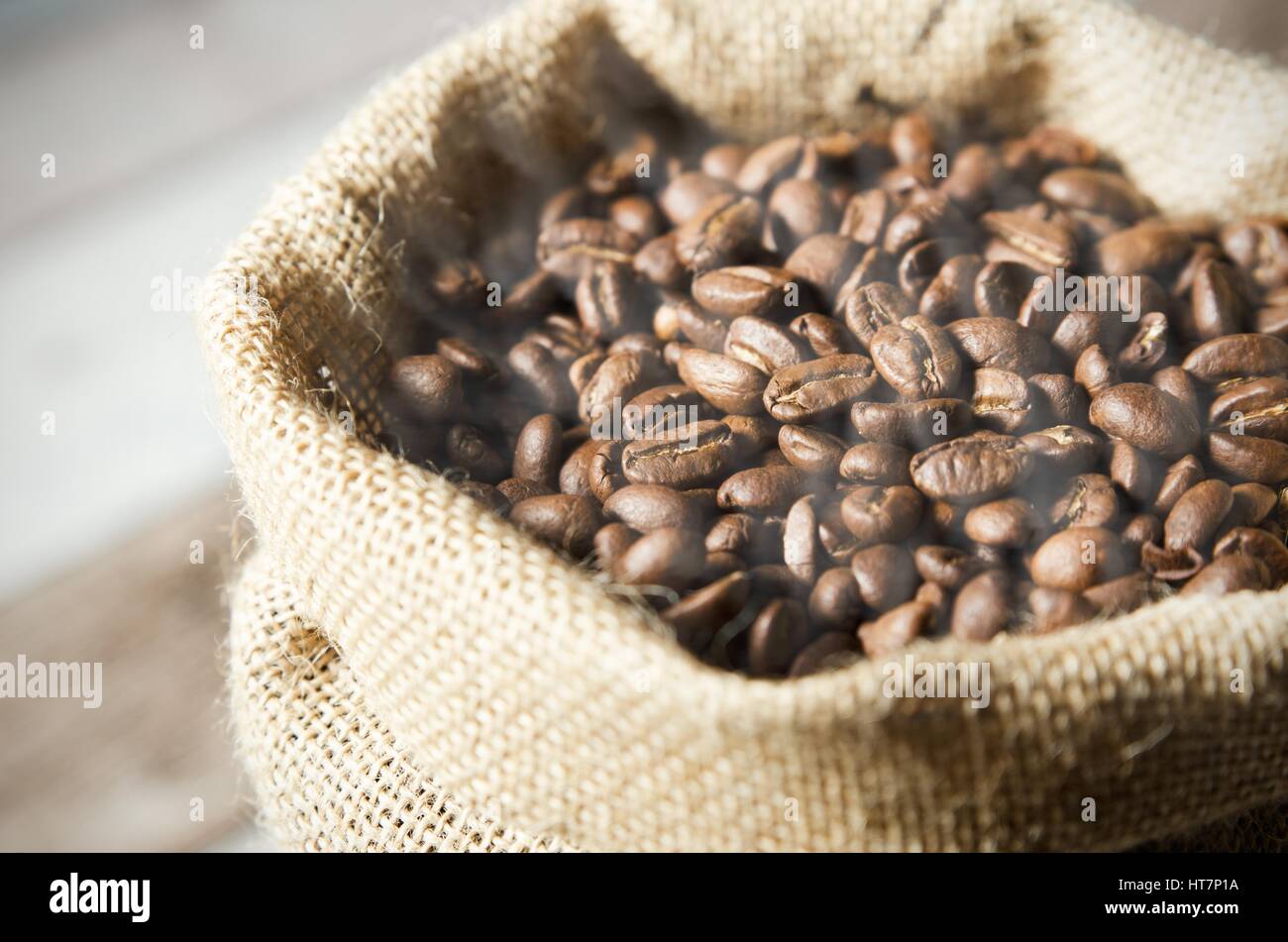 Close up i chicchi di caffè in juta Sacco sul tavolo di legno Foto Stock