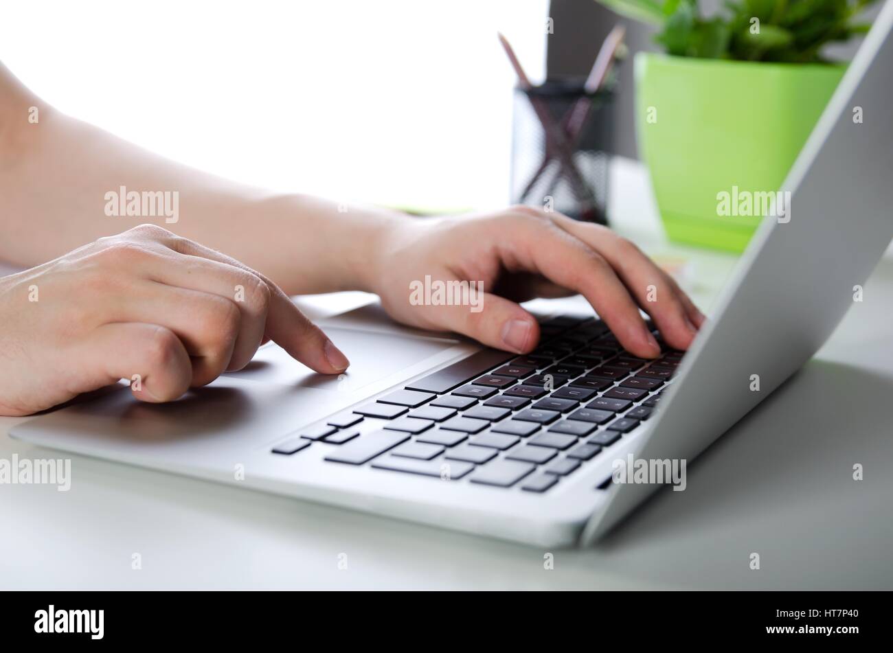 Uomo al lavoro con i moderni laptop in ufficio. Le mani la digitazione sulla tastiera Foto Stock