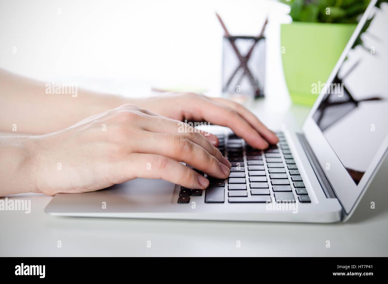 Uomo al lavoro con i moderni laptop in ufficio. Le mani la digitazione sulla tastiera Foto Stock