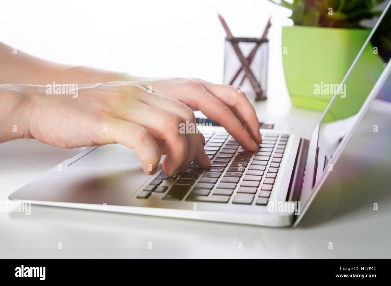 Uomo al lavoro con i moderni laptop in ufficio. Le mani la digitazione sulla tastiera Foto Stock
