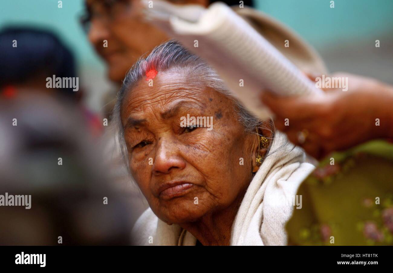 Kathmandu, Nepal. 8 Mar, 2017. Una donna anziana ascolta i religiosi storie raccontate da Sheela Sayami, un lavoratore sociale (non visibile) durante il suo racconto con i superstiti del terremoto, che sono anche i cittadini anziani, in occasione della Giornata internazionale della donna a Kathmandu, Nepal. Sheela Sayami, un lavoratore sociale corre un non remunerative di organizzazione denominata ''Nhapangu Pala (primo passo in lingua Newari) che si impegna con le vittime del terremoto nel racconto e attività creative come la preparazione di lampade di filettatura. Più di 60 cittadini anziani di età compresa tra 70 a 96 anni di raccogliere tutti i giorni di condividere i loro sentimenti e si impegnano in dif Foto Stock
