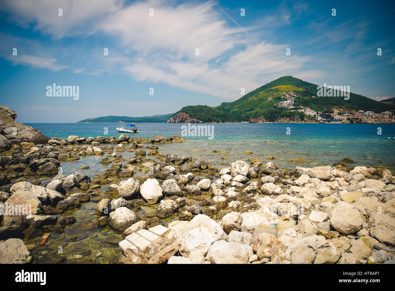 Spiaggia rocciosa sulla costa dell'isola con fantastica vista sulle montagne Foto Stock