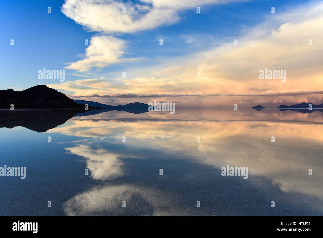 Atmosfera serale, montagne con la riflessione nel lago, acqua allagata Salt Lake, Salar de Uyuni, altiplano, Bolivia Foto Stock