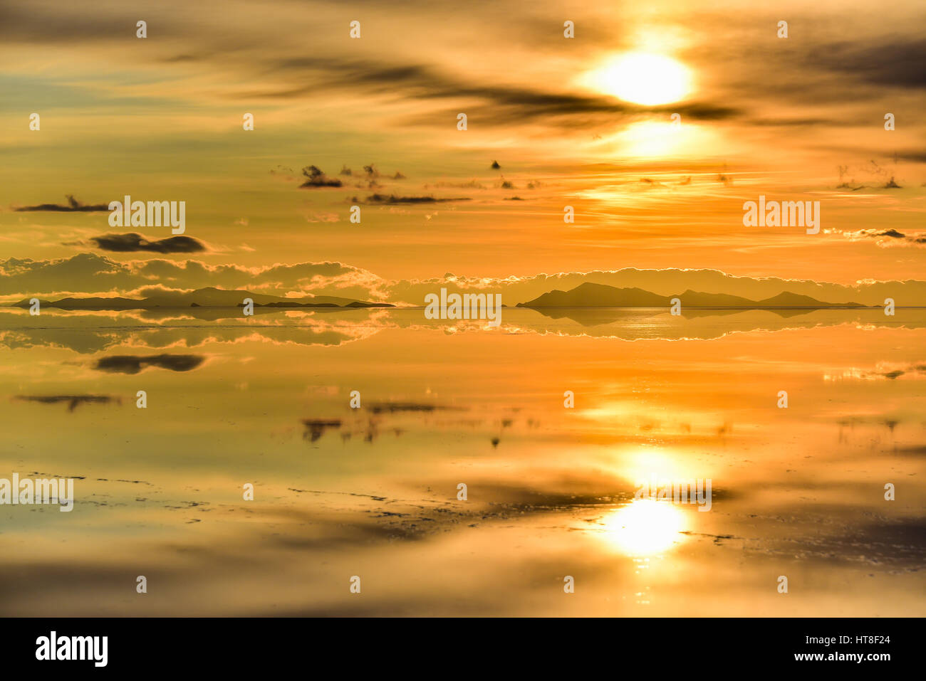 Sunset, montagne con la riflessione nel lago, acqua allagata Salt Lake, Salar de Uyuni, altiplano, Bolivia Foto Stock