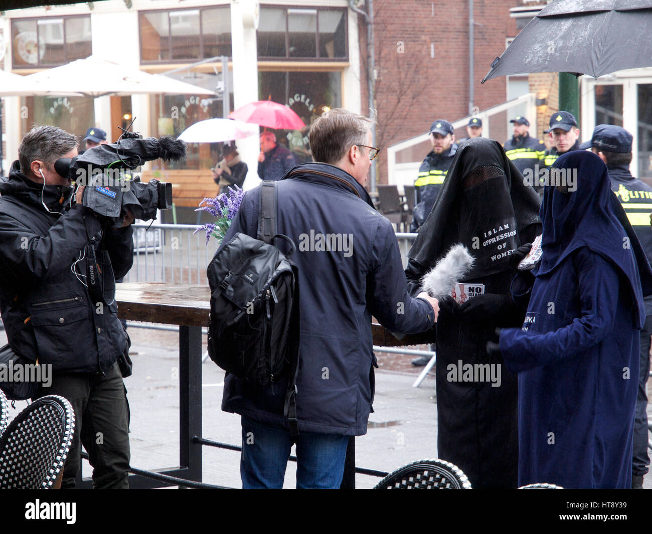 Sostenitori Pegida vestito in burqa intervistata dal team di giornalisti a Breda, Paesi Bassi Foto Stock