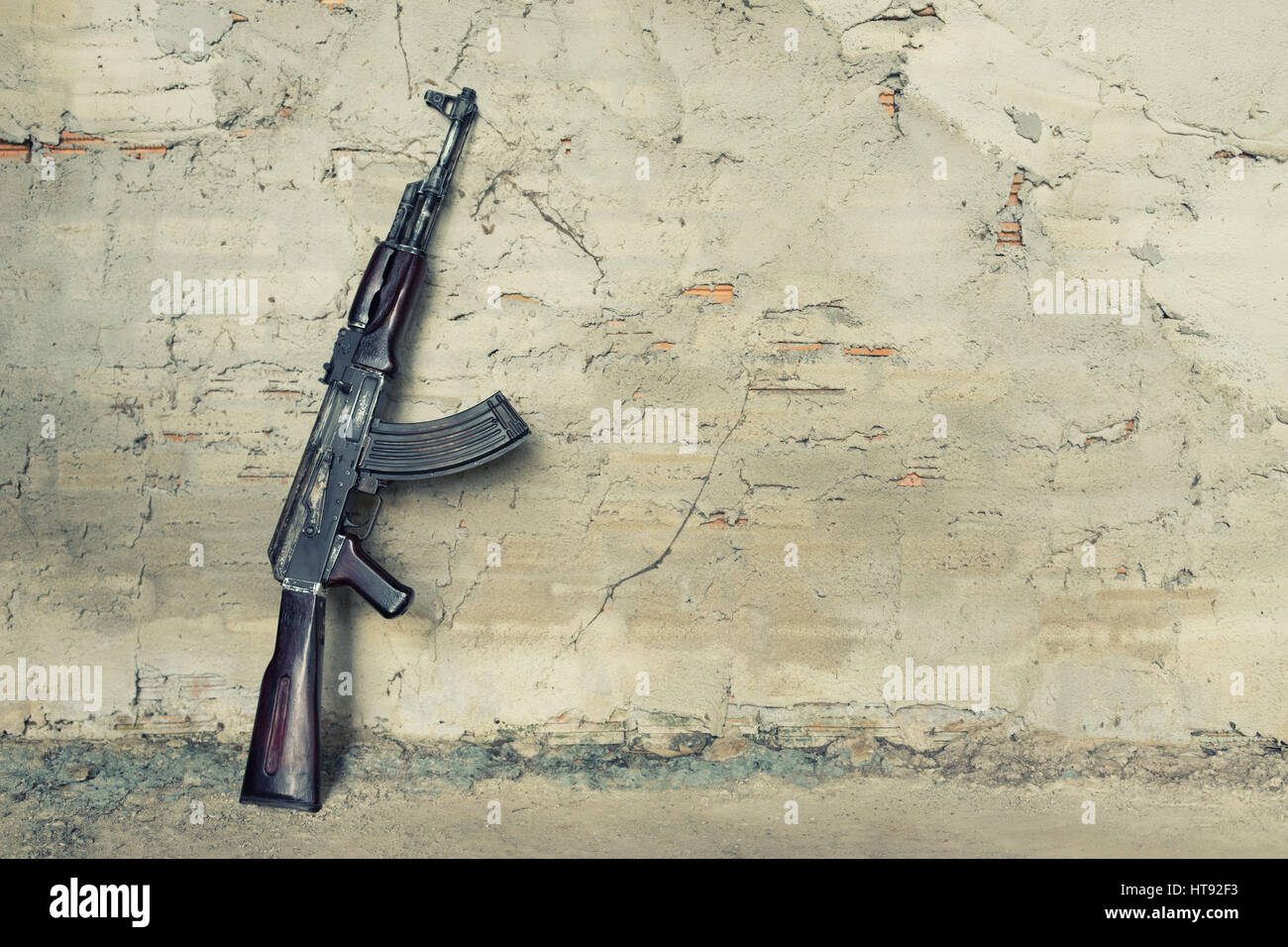 Vecchio mitragliatore kalashnikov AK-47 contro il muro Foto Stock