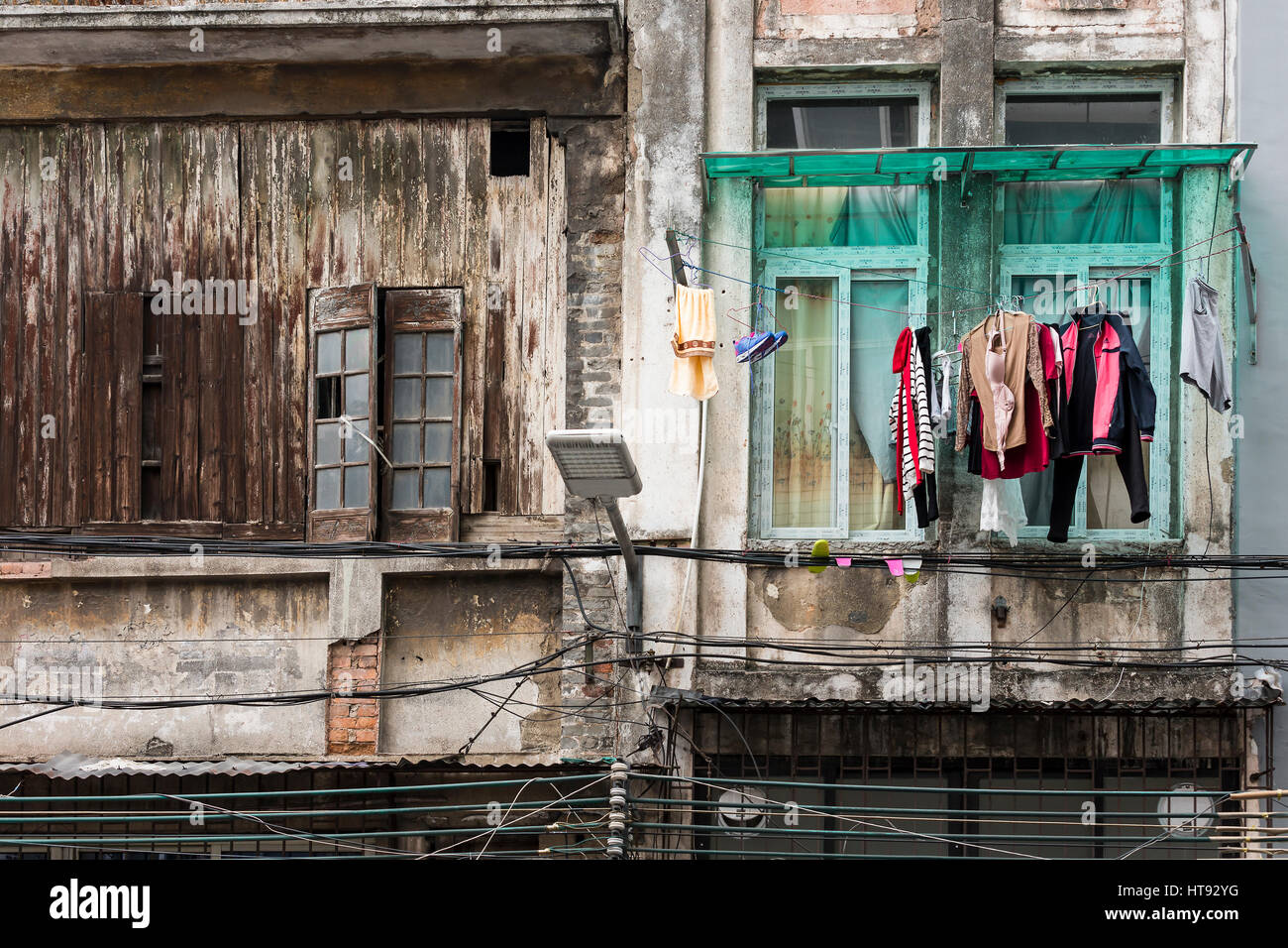 Abbigliamento appeso su un vecchio edifici in un quartiere storico di Guangzhou, Cina Foto Stock