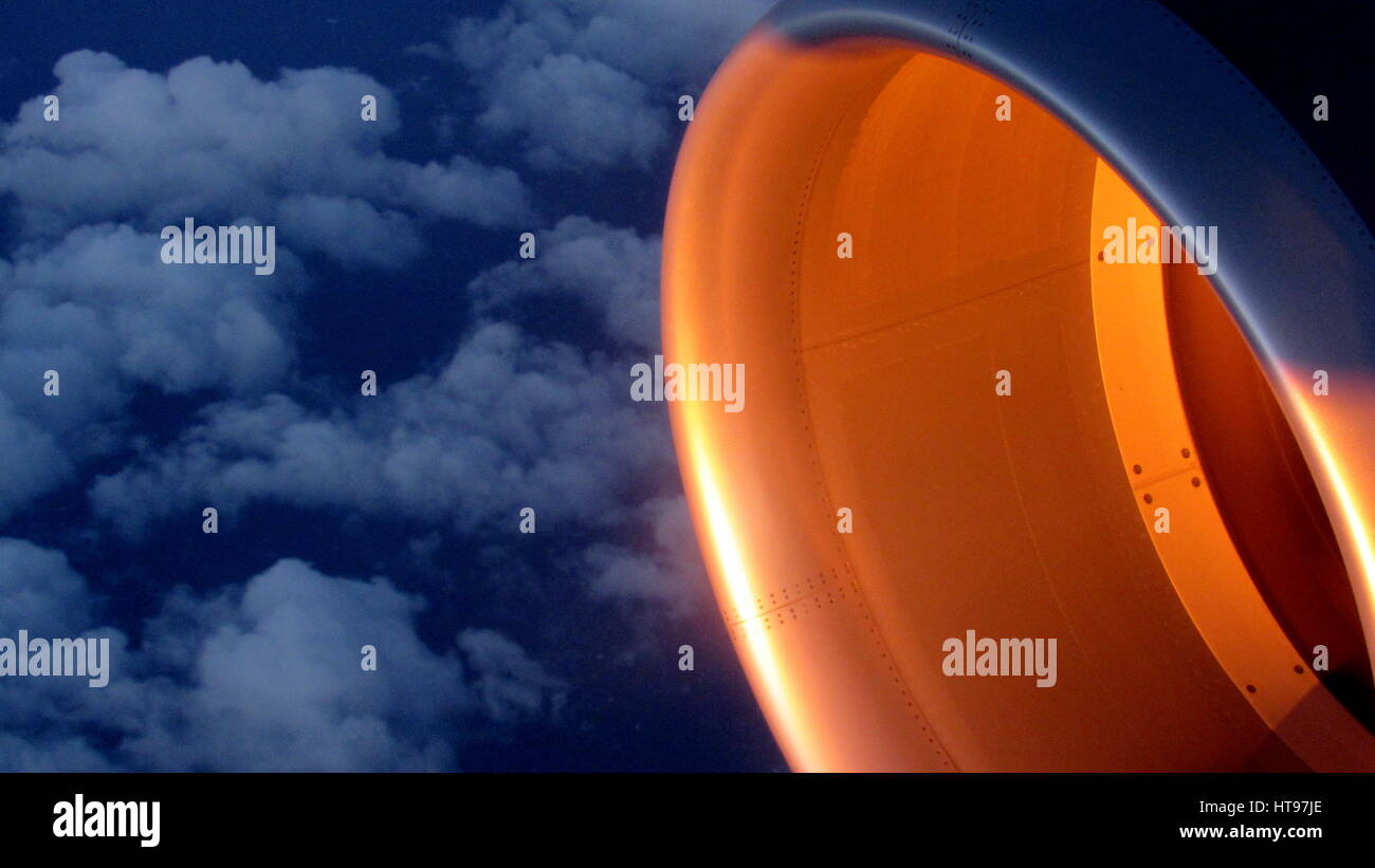 Gli aeromobili jet piano in sunrise a 35000 piedi mostra luce con dettagli battenti alto sopra blu scuro delle acque dell'oceano con le nuvole sullo sfondo Foto Stock