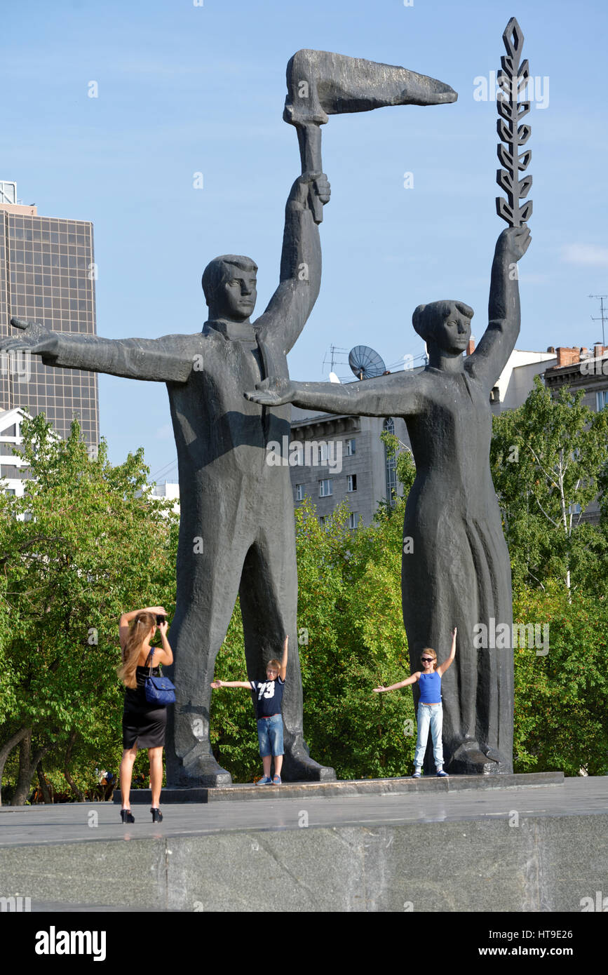Famiglia fare foto contro il frammento del monumento a V. I. Lenin sulla piazza principale di Novosibirsk, Russia Foto Stock