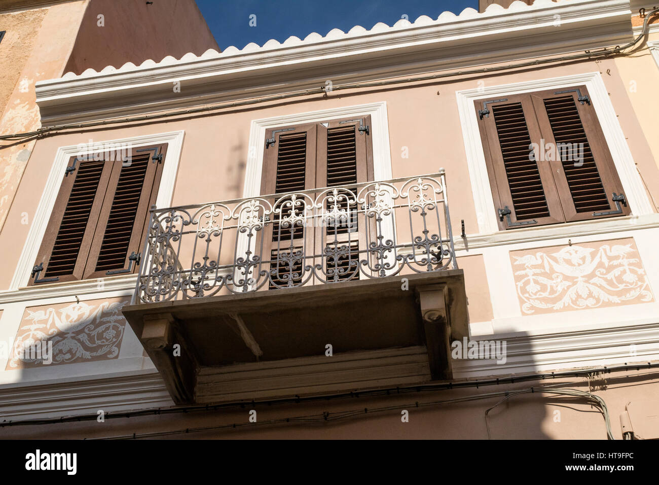 Dettaglio di un balcone e di colore marrone, e persiane a lamelle su un edificio nella strada principale di La Maddalena - Arcipelago di La Maddalena in Sardegna, Italia. Foto Stock