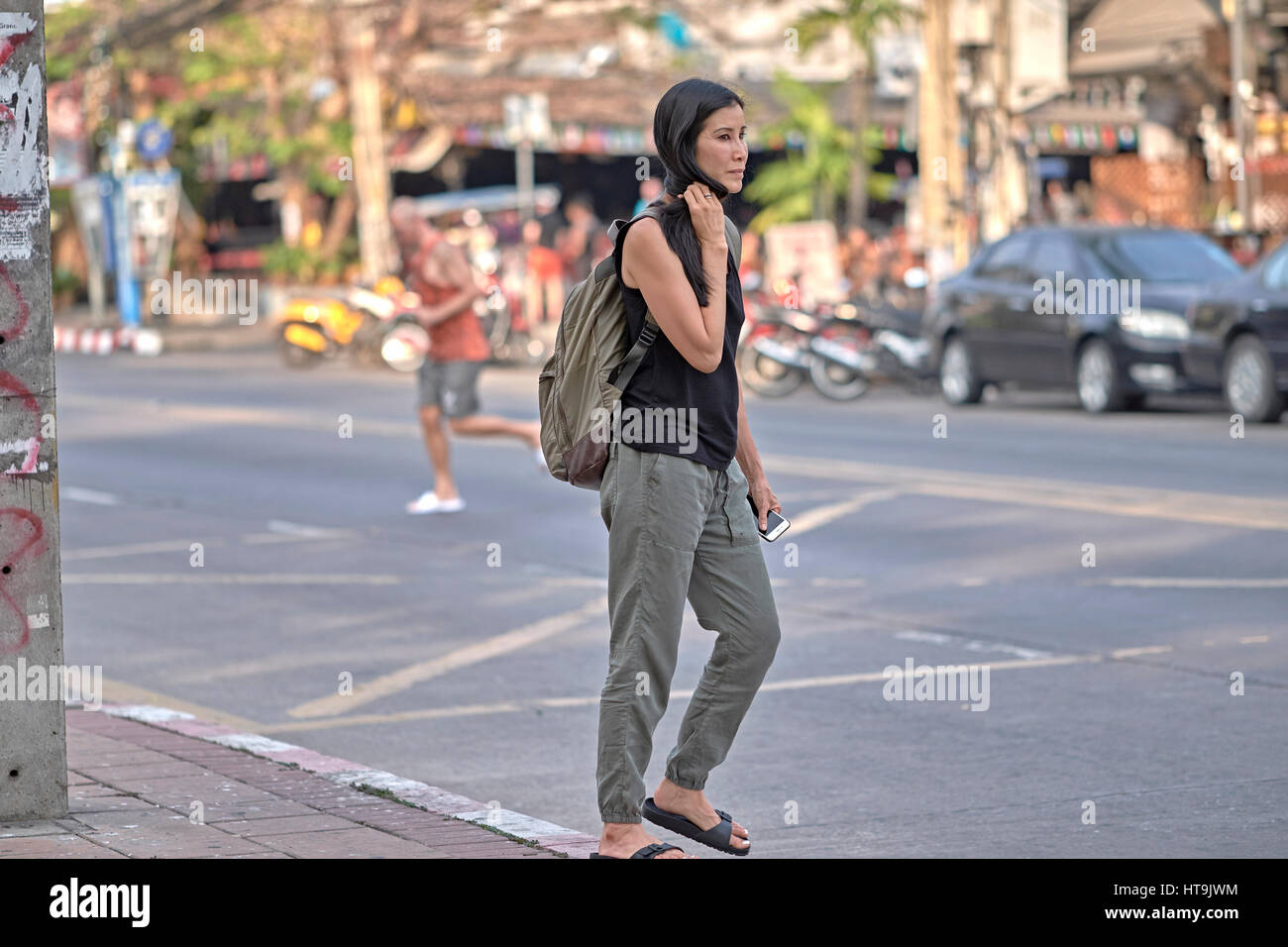 Donna con uno zaino che viaggia da sola per le strade della Thailandia del sud-est asiatico. Foto Stock