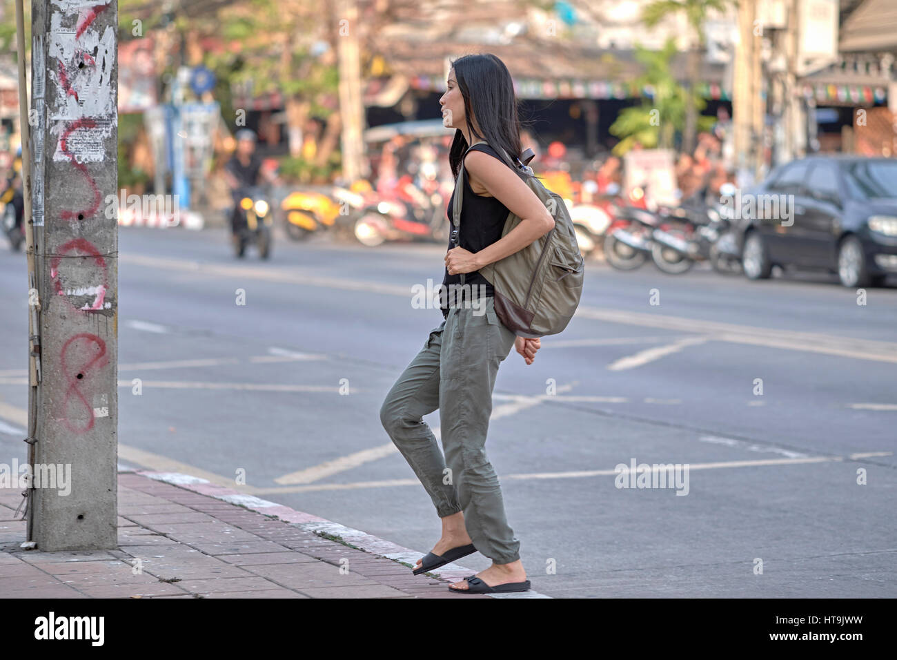 Donna con uno zaino che viaggia da sola per le strade della Thailandia del sud-est asiatico. Foto Stock