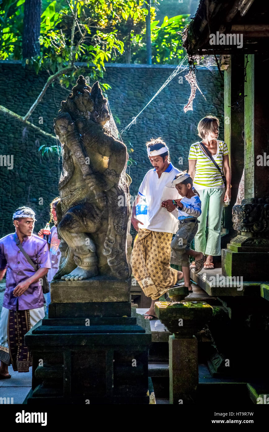 I visitatori locali e i viaggiatori stranieri scenderanno su una scala ornata da una scultura balinese di guardiano della porta a Tampaksiring, Bali, Indonesia. Foto Stock