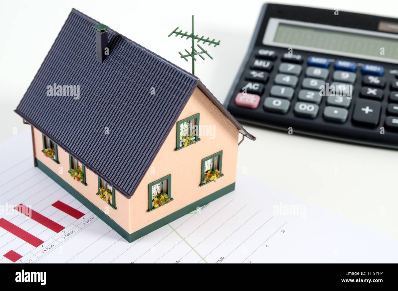 Home finanze o il salvataggio di una casa. Casa in miniatura e calcolatrice Foto Stock
