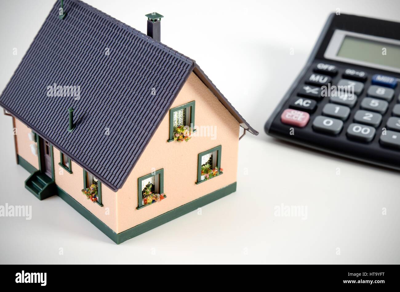 Home finanze o il salvataggio di una casa. Casa in miniatura e calcolatrice Foto Stock